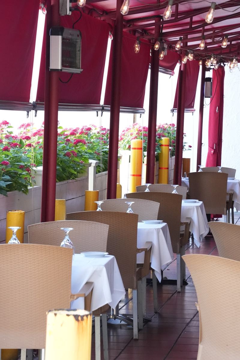 A tall view over the Casa Mia patio tables set with white cloths and glassware
