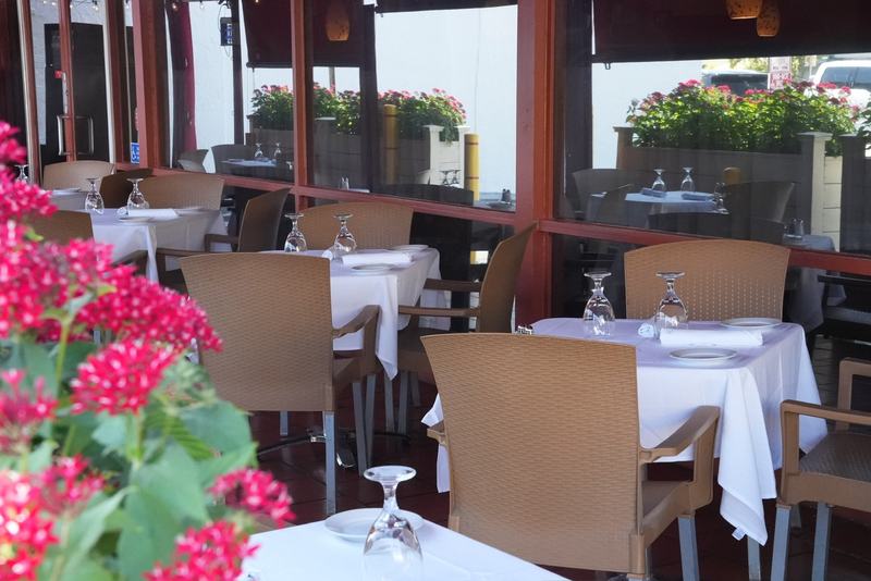 Evening tables on the Casa Mia Trattoria patio in North Miami under string lights